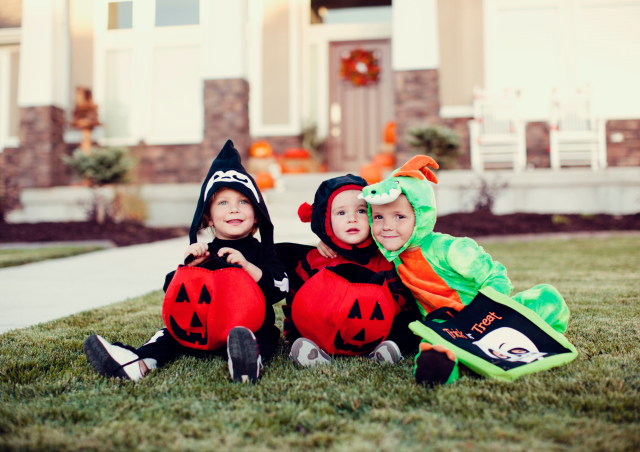 Children celebrate Halloween on the lawn dressed up and ready to trick or treat